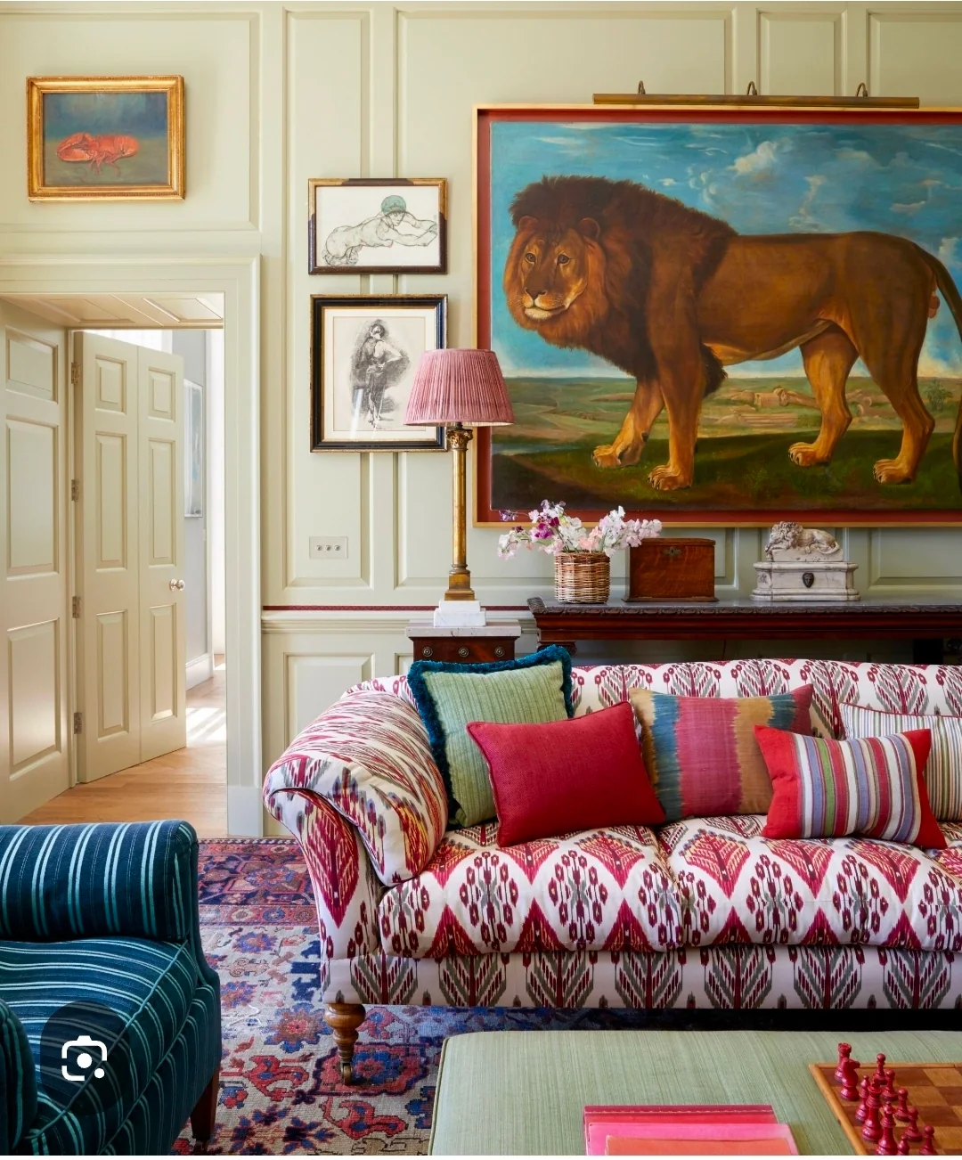 Colourful upholstered seating beneath a horse painting in a period room.