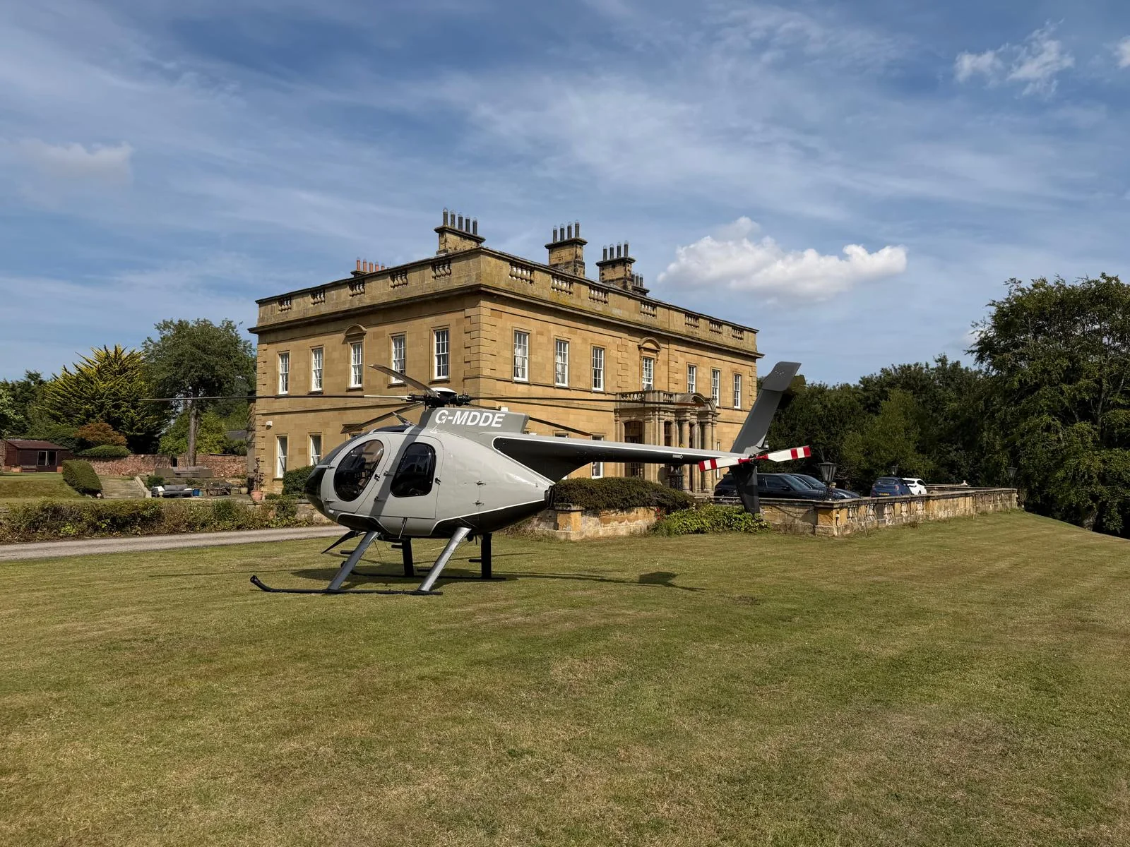 A helicopter on the lawn with Rudby Hall in the background.
