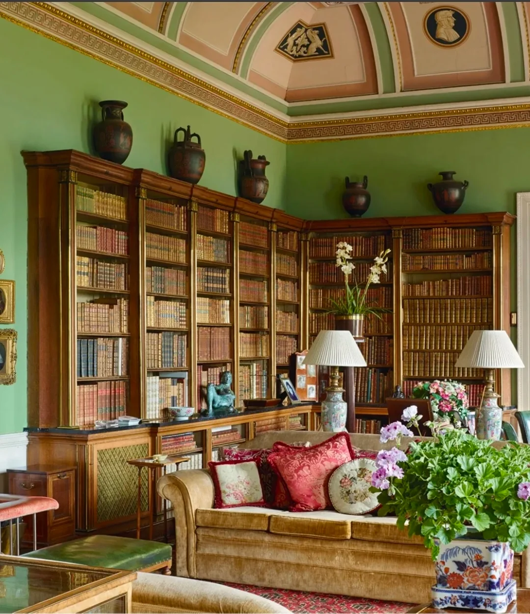 Bookshelves and comfortable seating in a green-walled library.